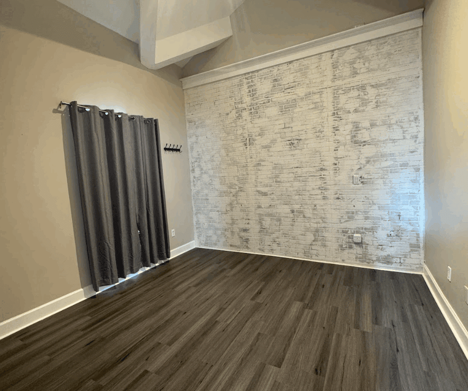 Modern salon or studio space with exposed brick wall and contemporary flooring.